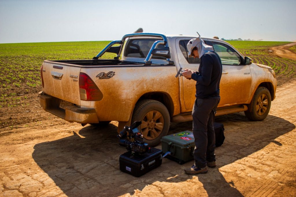A BPS drone operator stands by his 4x4 pick up truck in a soy field in Mato Grosso, shooting an agricultural documentary for an international brand.