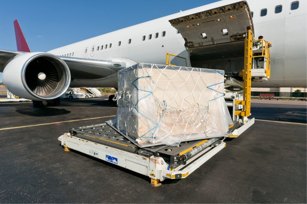 Production gear being loaded into a plane through the work of a freight forwarding service.