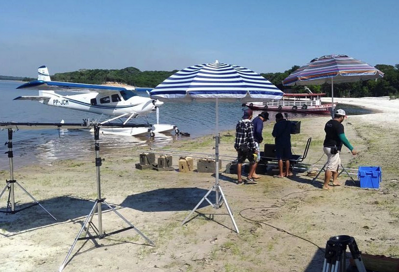 A production set at a beach on the Rio Negro, featuring support from a hydroplane, which BPS often uses for rapid transportation on shoots in remote areas of the Amazon.
