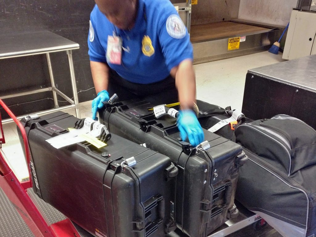 Policial conferindo malas