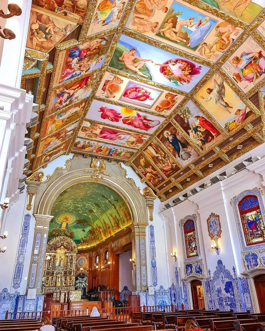 The image shows the ornate Baroque-style ceiling of the Igreja Nossa Senhora do Brasil in São Paulo’s Jardins neighborhood, a 1940s church modeled after 18th-century Portuguese colonial architecture, known for its painted ceilings, blue azulejos, and popularity as a wedding venue.