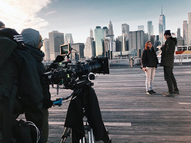 cena com atores em uma cidade com prédios ao fundo em cena de novela